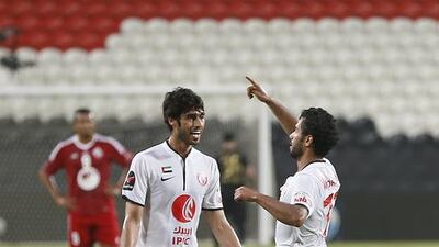 Sultan Bargash of Al Jazira, right, celebrates scoring the game-winner against Sharjah on Saturday night in Abu Dhabi. Al Ittihad