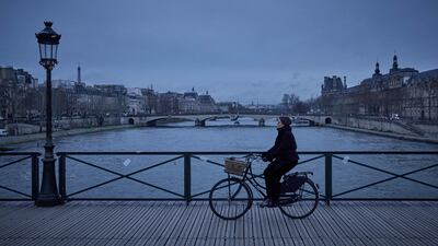 A woman rides a bike on the Pont des Arts bridge over the Seine river, in Paris. AFP