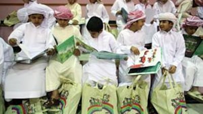 Children from the Al Hamdania Boys School look through books given to them by Kalima.