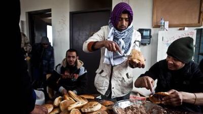 Libyan rebels make tuna sandwiches for their comrades at a rebel position in Ras Lanuf.