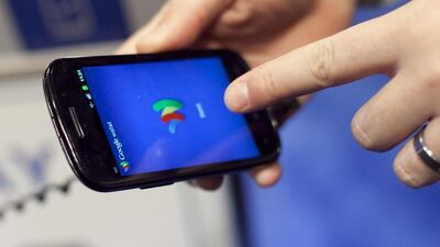 A person tries a smartphone loaded with Google Wallet at the National Retail Federation in New York. Mark Lennihan / AP Photo