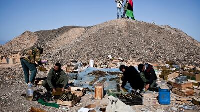 Anti-Qaddafi rebels load anti-aircraft ammunition at an ammo dump near Ras Lanuf.