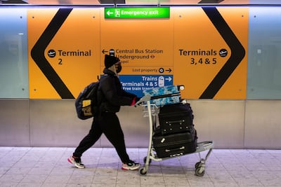 A woman wearing a protective face mask prepares to board a flight at London's Heathrow Airport. Getty Images