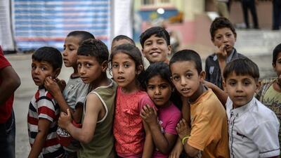 Young Syrian refugee children line up for food as Syrians break their fasting on June 20, 2015 in Akcakale, Turkey, during the holy month of Ramadan. Bulent Kilic / AFP photo