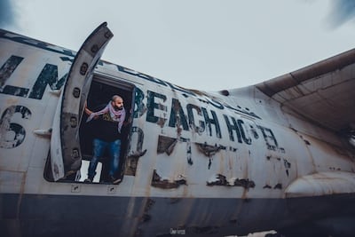 Emirati filmmaker Aiham Al Subaihi looking out of the abandoned plane in Umm Al Quwain. Omar Tartoub