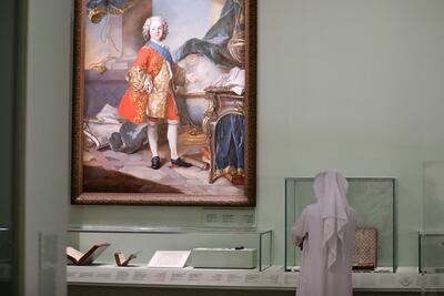 A visitor explores the artwork and artefacts showcased at the new exhibition 'Versailles and the World' at Louvre Abu Dhabi. Khushnum Bhandari / The National