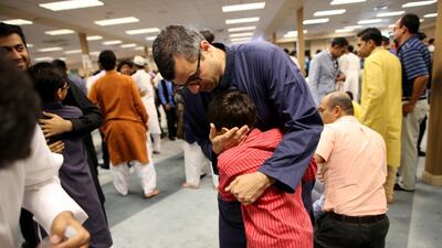 Muhammad Ali hugs his son Murtaza, 9, after prayer at the Muslim Community Association in Santa Clara.