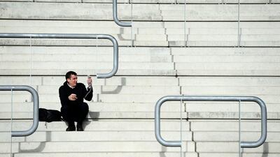 A man takes a picture of his surroundings during Champion Day of the Cheltenham Festival at Cheltenham Racecourse in England. Harry Trump / Getty Images