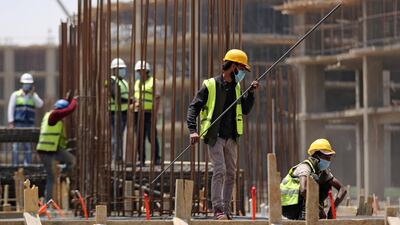 Workers wearing protective face masks stand on a building under construction in the New Administrative Capital (NAC), east of Cairo, amid concerns about the spread of the coronavirus disease (COVID-19), in Egypt May 6, 2020. Picture taken May 6, 2020. Reuters