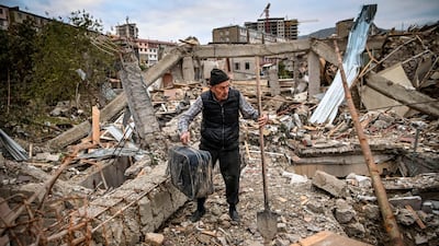 Retired police officer Genadiy Avanesyan, 73, searches for belongings in the remains of his house, which is said was destroyed by Azeri shelling, in the city of Stepanaker. AFP