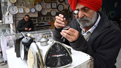 A clockmaker repairs a watch at his street stall in Amritsar, India. AFP