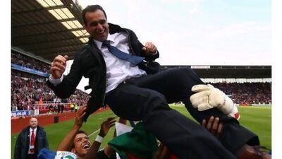 Wigan players throw manager Roberto Martinez in the air after avoiding the drop.
