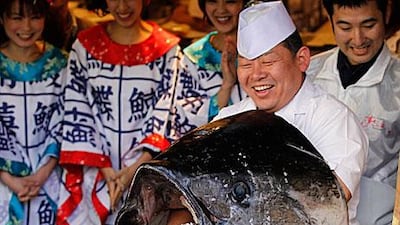 A chef holds a head of a giant bluefin tuna after cutting its meat at a sushi restaurant in Tokyo yesterday. The 269 kilogram fish, caught off the coast of northern Japan, was sold for at a record price of US $736,234 (Dh2.7 million) in the country’s first fish auction of the year.