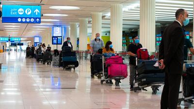 Passengers wearing masks wait at ticketing counter for flights at Dubai International Airport's Terminal 3 in Dubai. The coronavirus pandemic has hit global aviation hard, particularly at the Dubai airport, the world's busiest for international travel, because of restrictions put in place globally to contain the virus. AP Photo