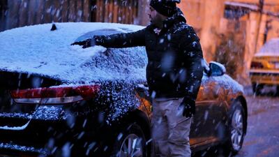 A man cleans the snow off of his car in Baghdad, Iraq. AP Photo