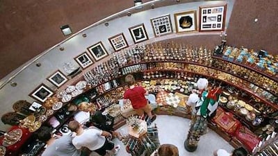 Tourists browse through a souvenir shop in Dubai. Both Dubai and Abu Dhabi are aiming to increase the number of tourists visiting the UAE in the next few years. Jeffrey E Biteng / The National
