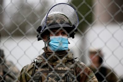 A member of the Washington State National Guard stands behind a security fence outside the Washington State Capitol. Reuters