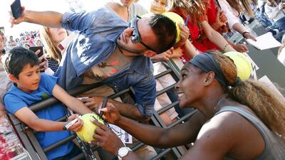 Serena Williams (R) of the US poses for a selfie with a supporter as she signs on a ball, after winning the women’s singles final match against Sara Errani of Italy, at the Rome Masters tennis tournament. Giampiero Sposito / Reuters