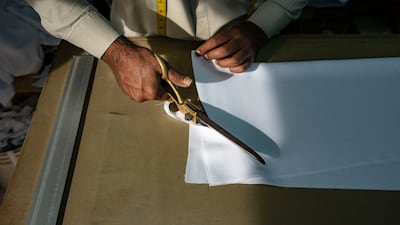 Shawkat Siyan from Muqbool Ahmed Tailoring cuts a pattern for an Eid outfit