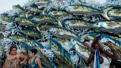 Brazilians take pictures next to the winning 2017 Rio Carnival float belonging to the Portela Samba School. Yasuyoshi Chiba / AFP