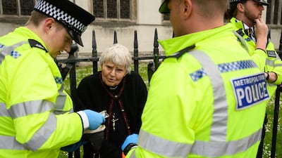 A member of the clergy speaks to police after being arrested for joining the protesters. Getty Images