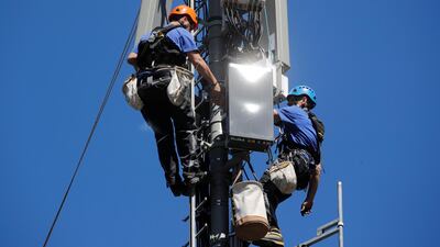 Technicians are roped up as they install 5G antennas. The new network is expected to carry 35 per cent of mobile data traffic globally by 2024, according to Ericsson. Reuters