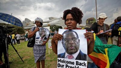 Supporters of Emmerson Mnangagwa, the man expected to become Zimbabwe's new president, hold a photograph of him as they arrive to show their support at Manyame Air Force base where Mnangagwa is expected to arrive later in the day in Harare, Zimbabwe Wednesday, Nov. 22, 2017. Mugabe resigned as president with immediate effect Tuesday after 37 years in power, shortly after parliament began impeachment proceedings against him. Ben Curtis / AP Photo