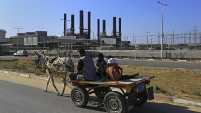 A father and his children ride their donkey cart past the now idle Gaza power plant at Nusseirat, in the central Gaza Strip on June 4, 2017. Gaza has the longest-ever daily power cuts. Adel Hana / AP