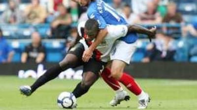 Portsmouth's Niko Kranjcar, right, grapples with Manchester City's Micah Richards during yesterday's clash.