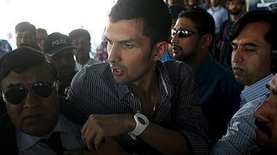 Zulqarnain Haider, centre, is whisked away by security upon his arrival at Islamabad airport, Pakistan last Monday after fleeing to the UK in November 2010 from Dubai.