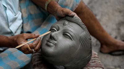 An Indian clay artist works on an unfinished face of Lord Shiva and Goddess Kali idols ahead of the Diwali festival at Kumartuly district in Kolkata, eastern India,18 October 2019. Kali, the Goddess of Power, is worshiped during the Hindu festival. EPA