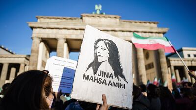 A protester holds a painted portrait of Mahsa Amini in Berlin, Germany. EPA