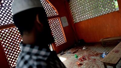 A Muslim resident in the town of Alutgama looks at a pool of blood and discarded belongings inside a mosque following clashes between Muslims and an extremist Buddhist group. AFP PHOTO / Ishara S. KODIKARA
