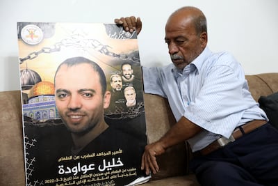 Mohamed Awawdeh with a poster of his son Khalil at the family's home in the West Bank village of Idnah, near Hebron. EPA