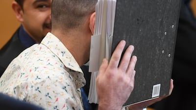The Iraqi defendant Taha Al Jumailly, who is believed to have belonged to ISIS, hides his face before the start of his trial in Germany. He is accused of genocide and murdering a young Yazidi girl he held as a slave. AFP
