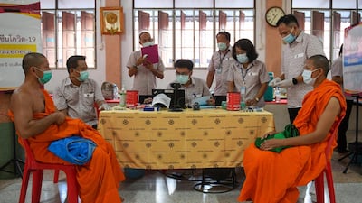 Buddhist monks wait to receive a dose of China's Sinovac coronavirus disease (COVID-19) vaccine at a temple in Bangkok, Thailand. REUTERS
