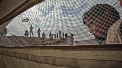 A Palestinian child stands outside a tent during a protest near Khan Younis in the southern Gaza Strip on March 30, 2018, which is observed as Land Day to mark the killing of six Arab Israelis during 1976 demonstrations against Israeli confiscations of Arab land. Said Khatib / AFP