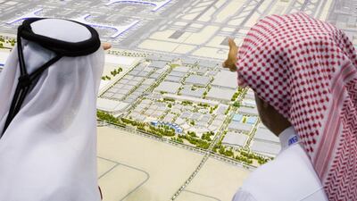 People look at a model of Dubai World Central's Al Maktoum International Airport. The airport, which opened last year, will eventually be able to accommodate up to 160 million passengers a year and 12 million tonnes of freight. Duncan Chard for the National.