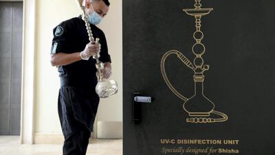 A shisha bottle is disinfected in a specially designed unit at Mezza House restaurant, Dubai. Chris Whiteoak / The National