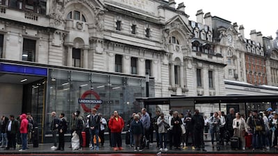 Commuters wait at a bus stop outside Victoria train station. AFP