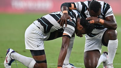 Fiji's Napolioni Bolaca (L) reacts with a teammate after winning the men's rugby sevens match against New Zealand at the Tokyo Stadium.
