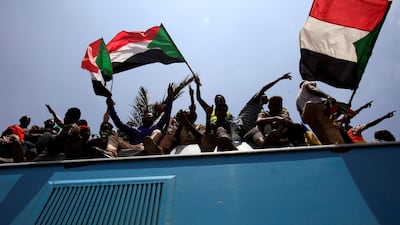 Sudanese civilians wave their national flags as they ride on the train to join in the celebrations of the signing of the Sudan's power sharing deal. REUTERS/Mohamed Nureldin Abdallah