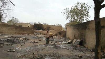 In this image shot with a mobile phone, a young girl stands amid the burned ruins of Baga.
