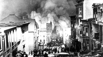 Residents stand amid ruined buildings on Sacramento Street, watching fires in downtown San Francisco after the earthquake in April 1906. Arnold Genthe / AP Photo