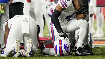 Buffalo Bills players and staff pray for Damar Hamlin during the first half of an NFL football game against the Cincinnati Bengals. AP