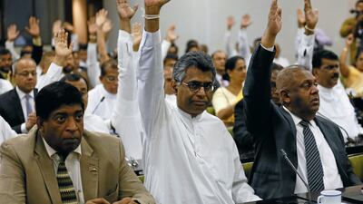 Lawmakers backing deposed Sri Lankan Prime Minister Ranil Wickremesinghe, raise hands during a meeting with Karu Jayasuriya. Reuters