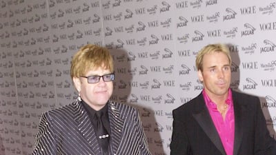 Elton John, in a sparkling pinstriped suit, and David Furnish arrive at Vogue's It's Fashion charity gala in Buckinghamshire, England on June 11, 2001. Getty Images