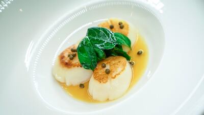 The pan-fried scallops served with lemon supreme confit with butter and fresh baby spinach. Courtesy Rue Royale / Anton Pole