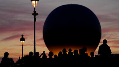 People wait for the balloon carrying the Olympic cauldron to rise above Tuileries Garden during the 2024 Summer Olympics. AP