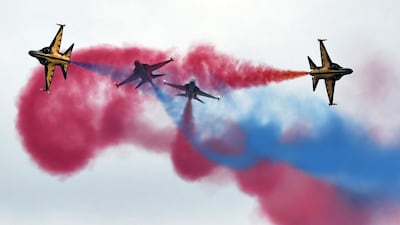 Coloured smoke billows as South Korea’s Black Eagles aerobatics team performs an aerial display at the Singapore Airshow. Roslan Rahman / AFP.